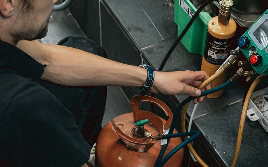 Técnico manipulando equipos de refrigerante en taller