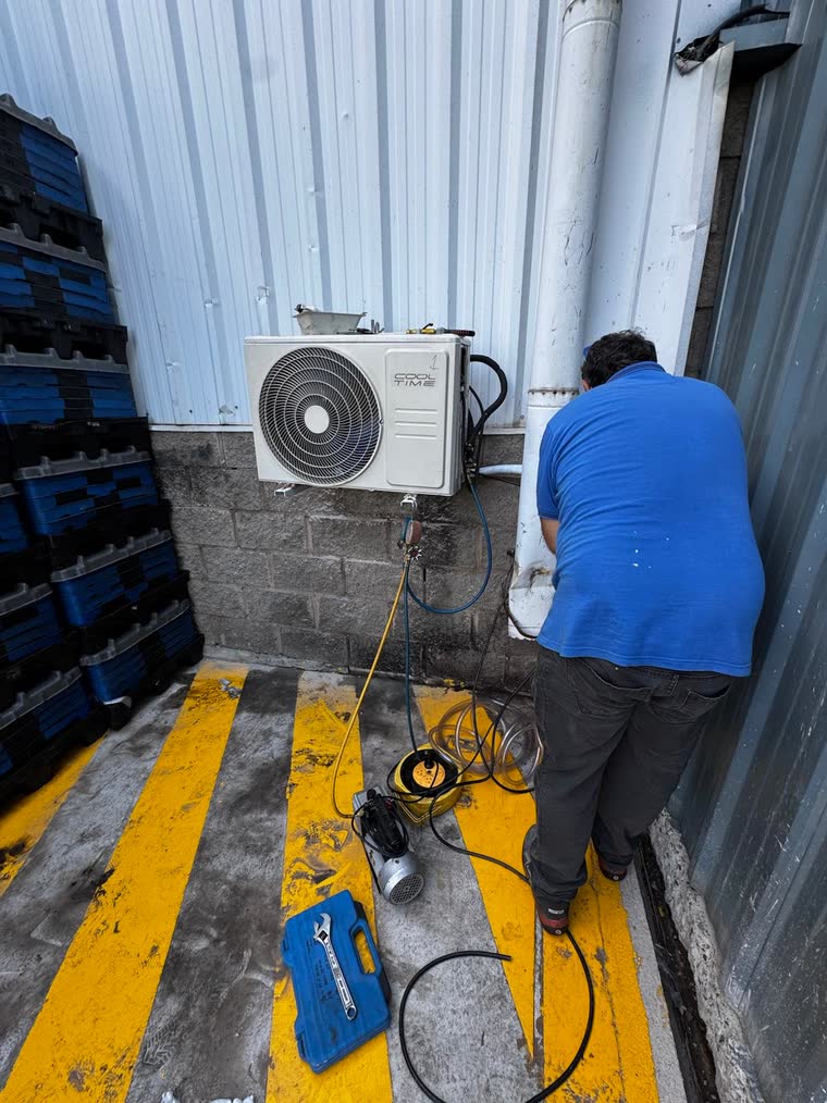 Técnico trabajando en una condensadora de aire acondicionado